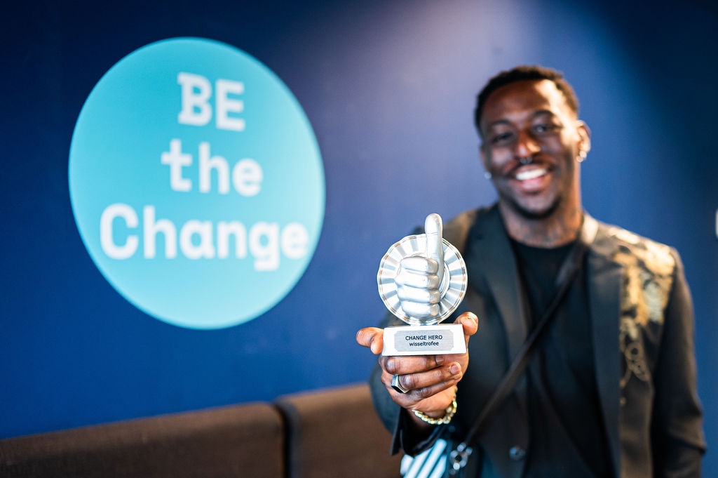 Lachende man Change hero in zijn hand